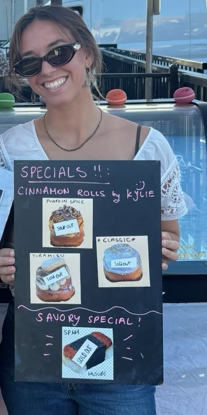 Kylie holding her chalkboard specials sign, every flavor tagged sold out